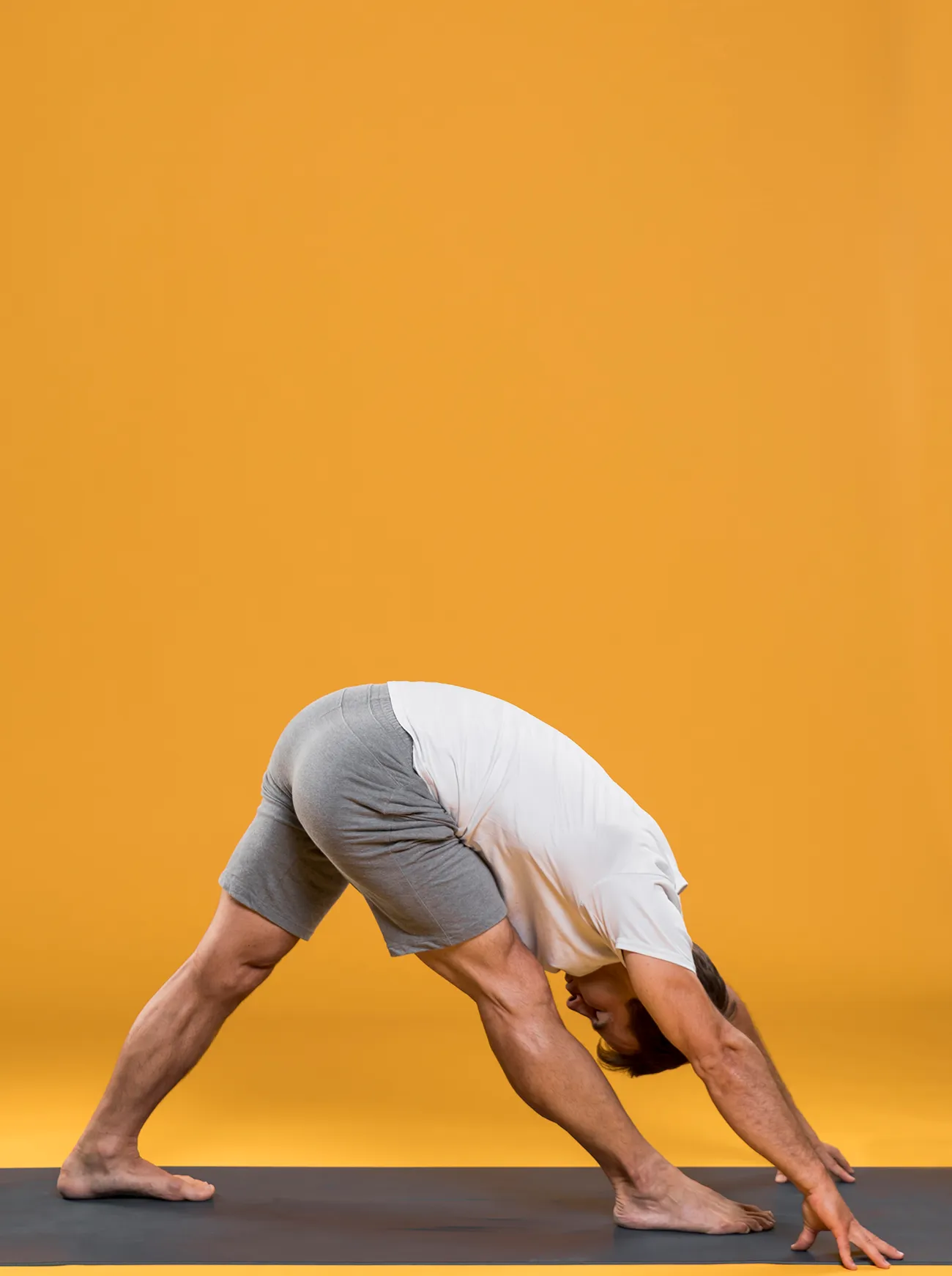 Persona in Uttanasana che allunga la catena posteriore della coscia nello yoga