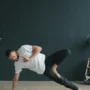 Uomo in posizione yoga con focus sulla stabilità e controllo del cingolo scapolare