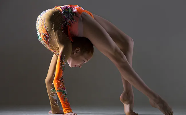 Ballerina in bridge che mostra flessibilità estrema della colonna e delle articolazioni