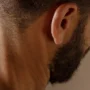 Uomo con barba in posa anatomica che illustra la muscolatura del corpo umano e la sua storia evolutiva