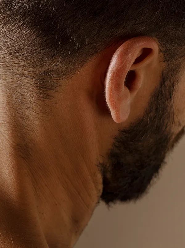 Uomo con barba in posa anatomica che illustra la muscolatura del corpo umano e la sua storia evolutiva