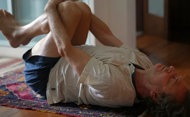 Persona che si alza rigida dal letto dopo un periodo di ridotta attività fisica e inattività