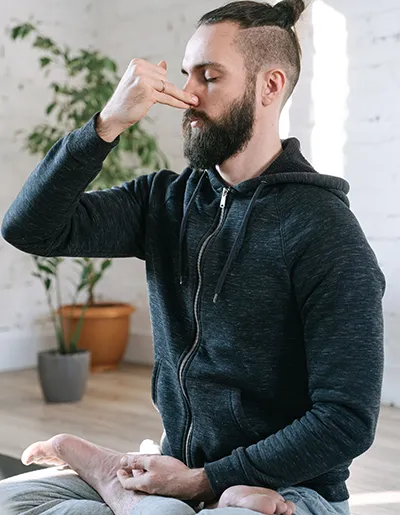 Uomo che pratica respirazione consapevole e controllo del respiro